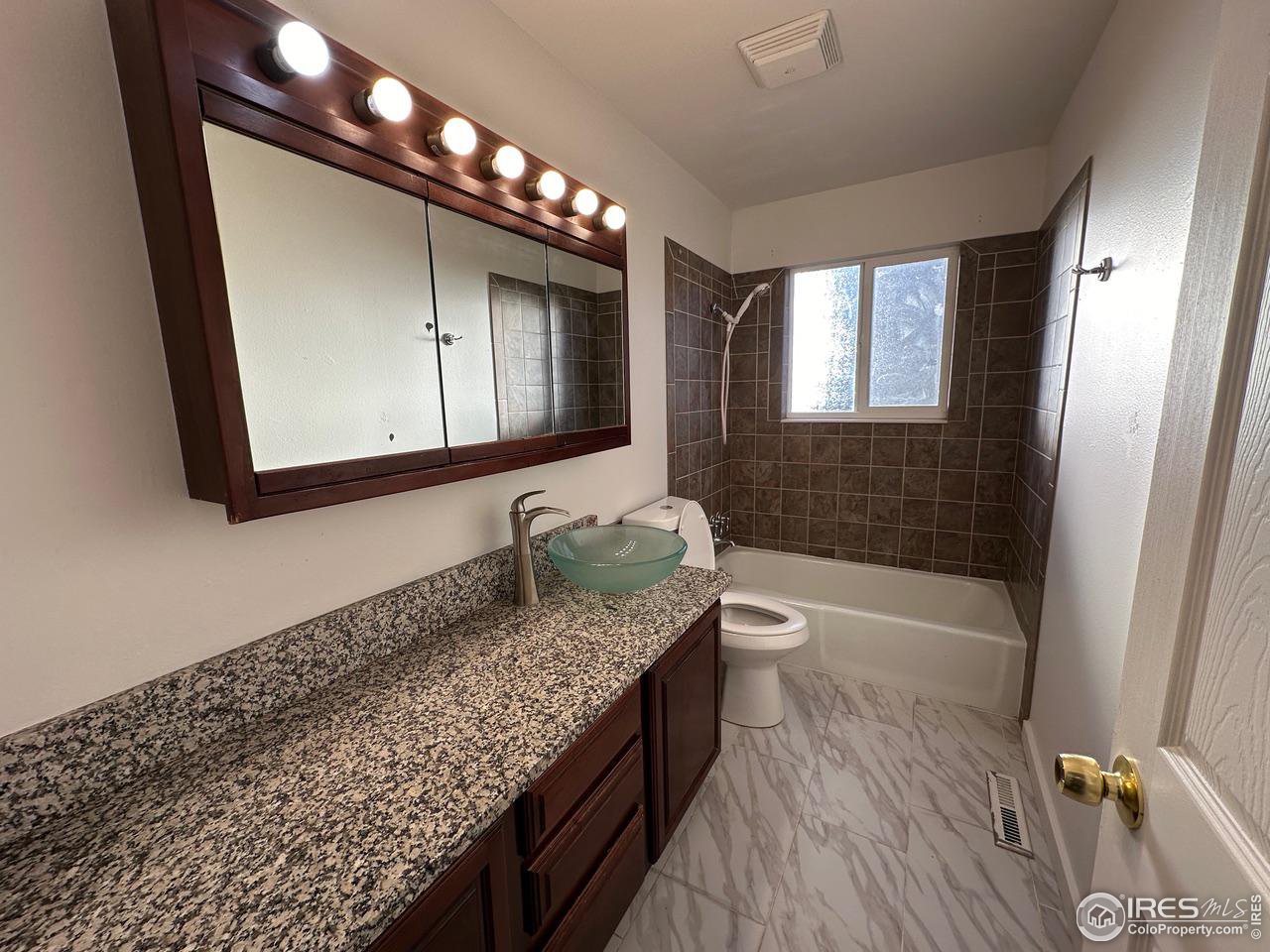 3209 5th Road Greeley, CO 80634 - Photo 3 of 37 a bathroom with a granite countertop tub sink and mirror