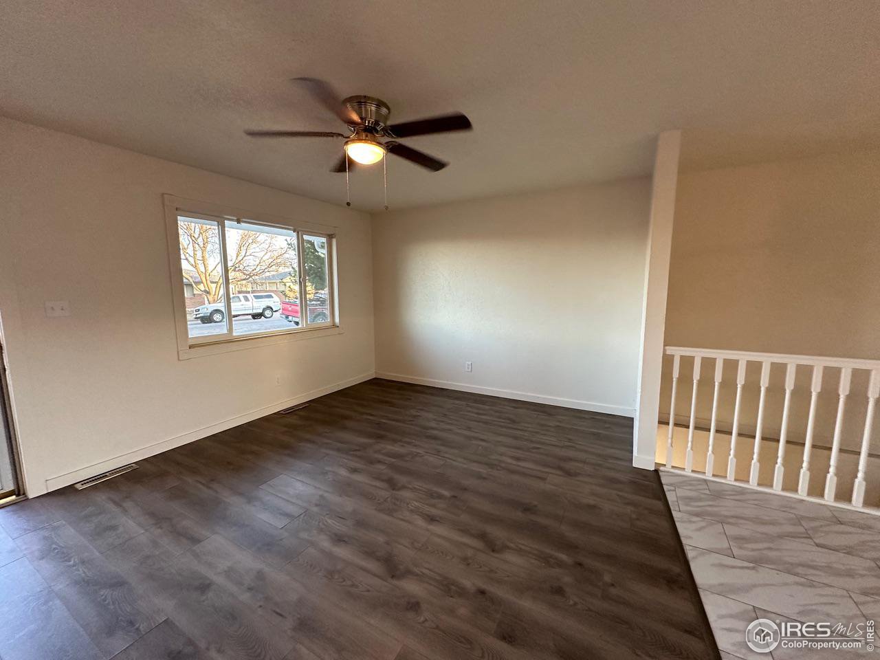 3209 5th Road Greeley, CO 80634 - Photo 10 of 37 a view of an empty room with wooden floor and a window