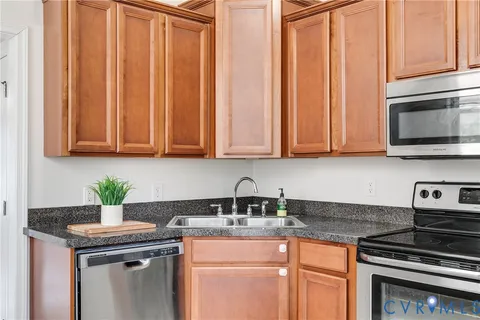 a kitchen with stainless steel appliances granite countertop a sink a stove and a microwave