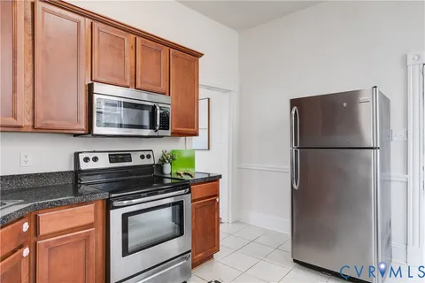a kitchen with stainless steel appliances granite countertop a refrigerator stove a microwave and cabinets