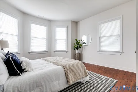 a bedroom with a bed and wooden floor