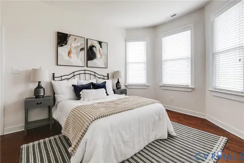 a bedroom with a bed and wooden floor