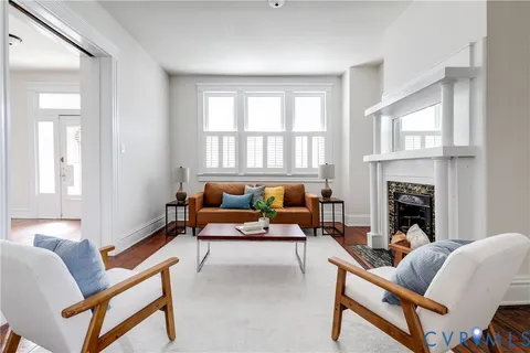 a living room with furniture a fireplace and a window