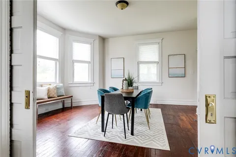 a dining room with furniture and wooden floor