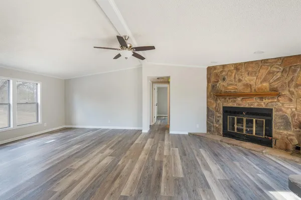 wooden floor fireplace and windows in an empty room