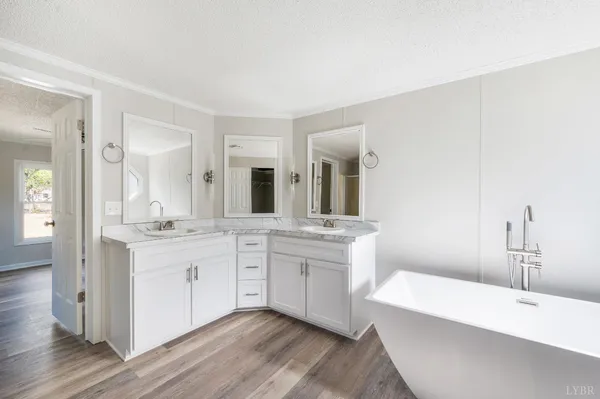a bathroom with a sink double vanity granite tub and mirror