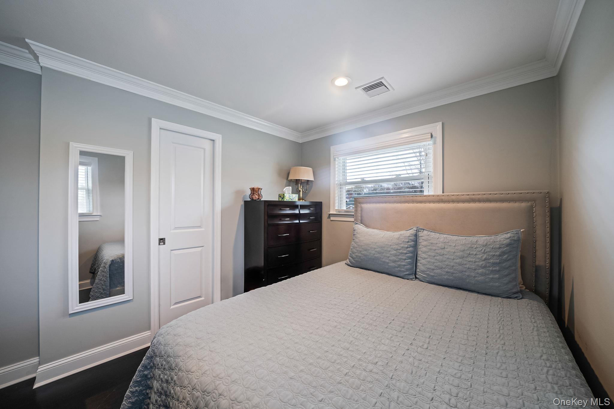 110 Stephen Road Bayport, NY 11705 - Photo 27 of 39 a bedroom with a bed and a chandelier