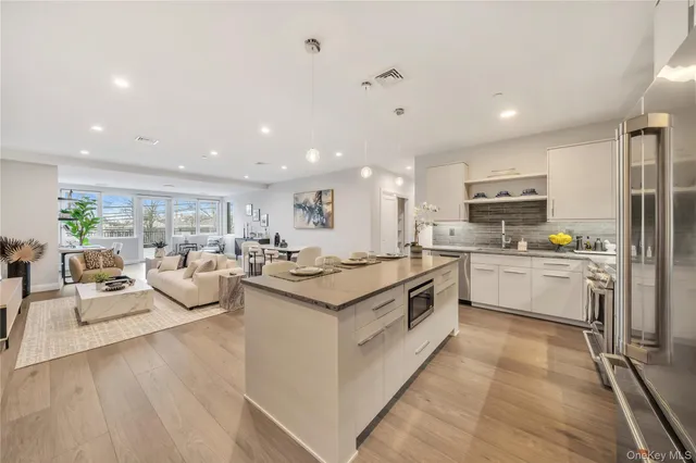 a large kitchen with stainless steel appliances lots of white cabinets