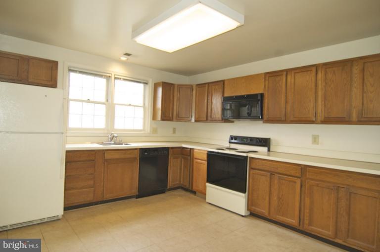 10703 Kings Riding Way, Unit 20113 Rockville, MD 20852 - Photo 1 of 17 a kitchen with stainless steel appliances granite countertop a stove and a sink