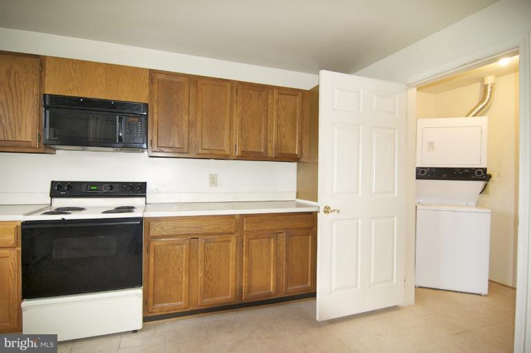 10703 Kings Riding Way, Unit 20113 Rockville, MD 20852 - Photo 10 of 17 a kitchen with stainless steel appliances granite countertop a stove a microwave and a refrigerator