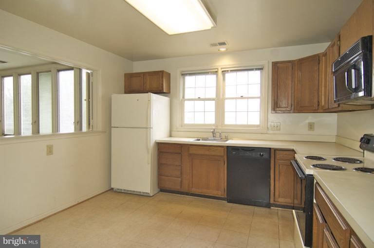10703 Kings Riding Way, Unit 20113 Rockville, MD 20852 - Photo 14 of 17 a kitchen with a refrigerator stove and sink