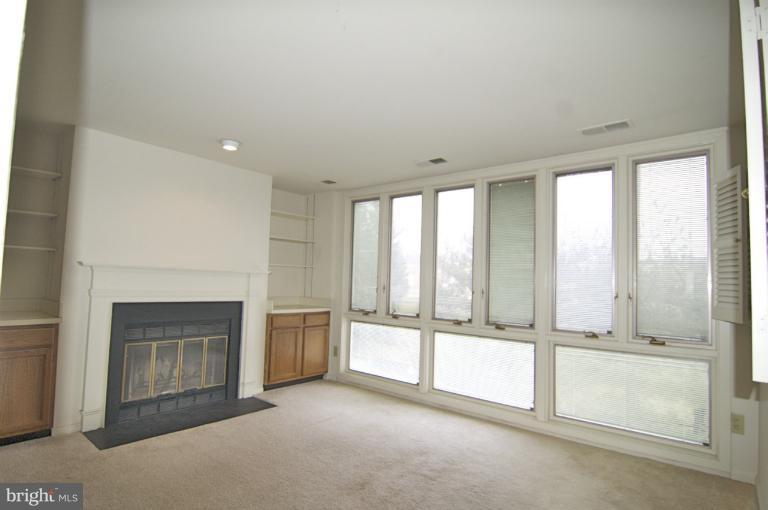 10703 Kings Riding Way, Unit 20113 Rockville, MD 20852 - Photo 4 of 17 a view of an empty room with a fireplace