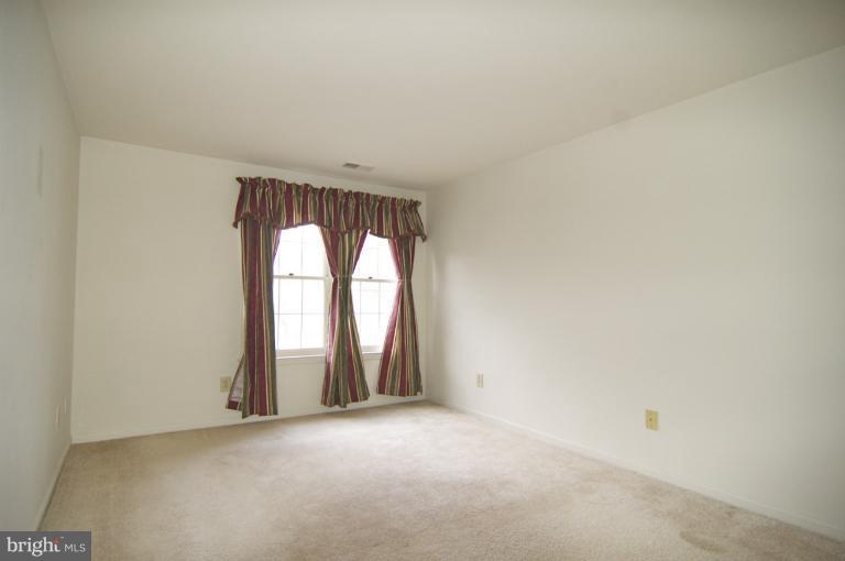 10703 Kings Riding Way, Unit 20113 Rockville, MD 20852 - Photo 5 of 17 an empty room with windows and sliding door