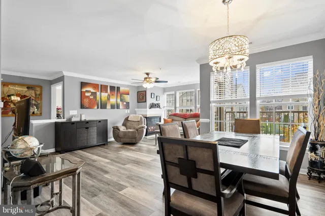 a view of a dining room with furniture a chandelier and wooden floor