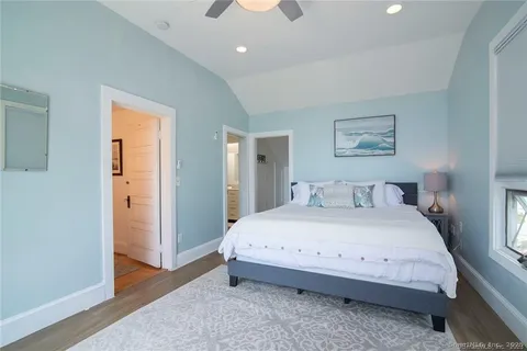 a spacious bedroom with a bed and a painting on the wall
