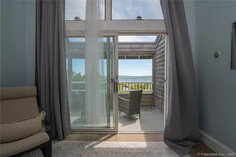 a view of a hallway with a glass door and a living room