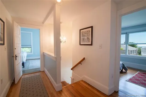 a view of a hallway with wooden floor and a livingroom