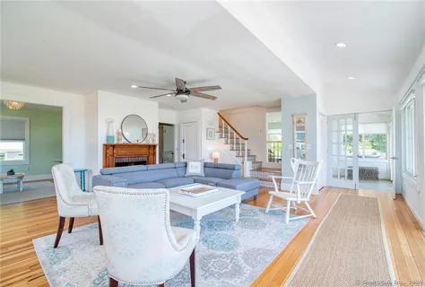 a living room with furniture a rug and wooden floor