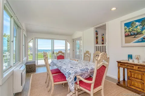 a view of a dining room with furniture a rug and wooden floor