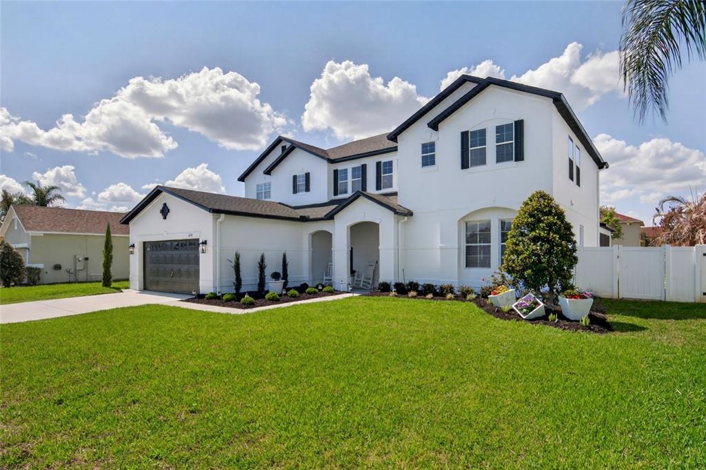 650 Setting Sun Drive Winter Garden, FL 34787 - Photo 2 of 60 a front view of a house with a yard and garage