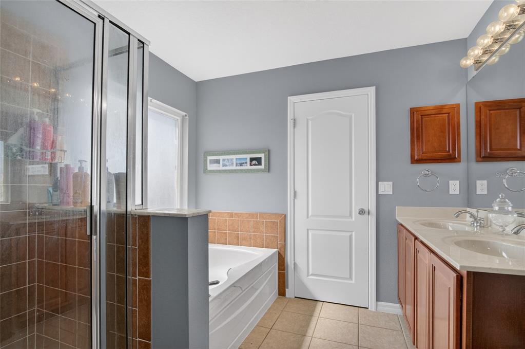 650 Setting Sun Drive Winter Garden, FL 34787 - Photo 29 of 60 a bathroom with a tub sink vanity and mirror