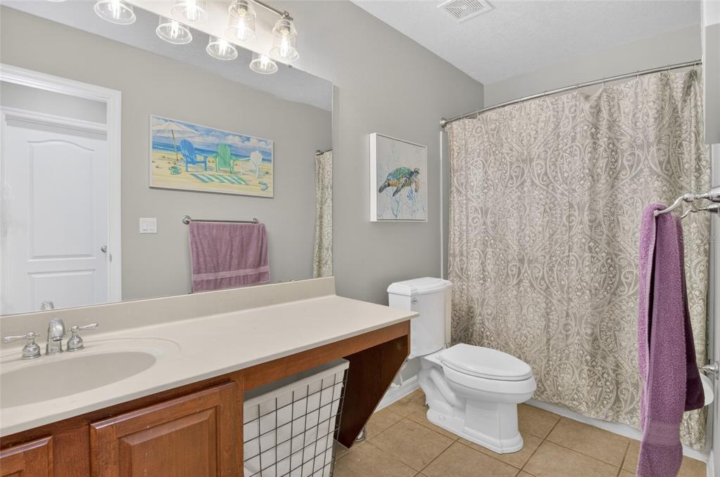 650 Setting Sun Drive Winter Garden, FL 34787 - Photo 34 of 60 a bathroom with a sink a toilet a mirror and shower curtain