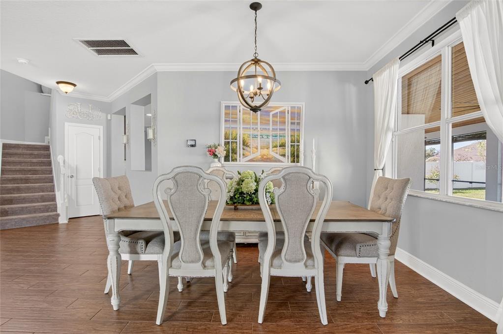 650 Setting Sun Drive Winter Garden, FL 34787 - Photo 9 of 60 a view of a dining room with furniture window and wooden floor