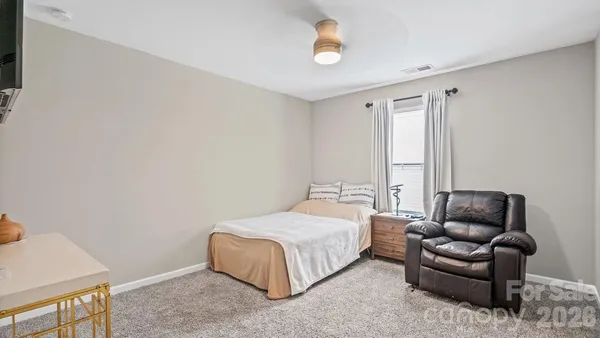 a bedroom with a bed couch and a window