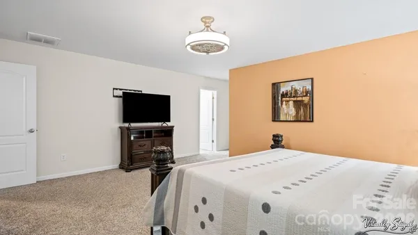 a bedroom with a bed and a flat screen tv