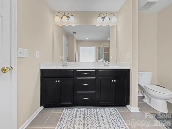 a bathroom with a granite countertop sink a toilet and a mirror