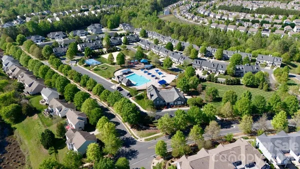 an aerial view of residential house with outdoor space and trees all around