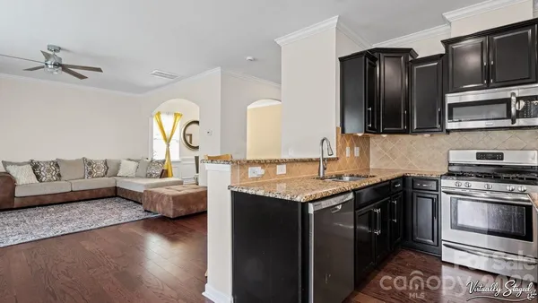a kitchen with granite countertop a stove and cabinets