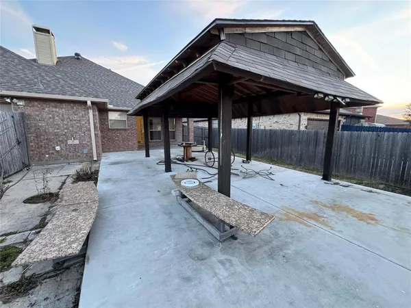 a backyard of a house with barbeque oven table and chairs