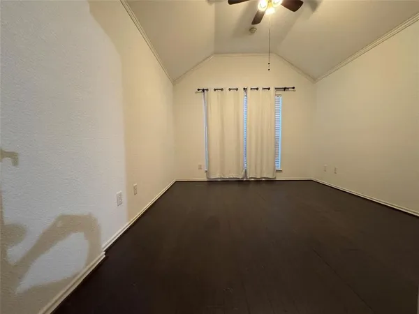 an empty room with a ceiling fan and window