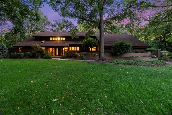 a view of a house with a big yard plants and large trees