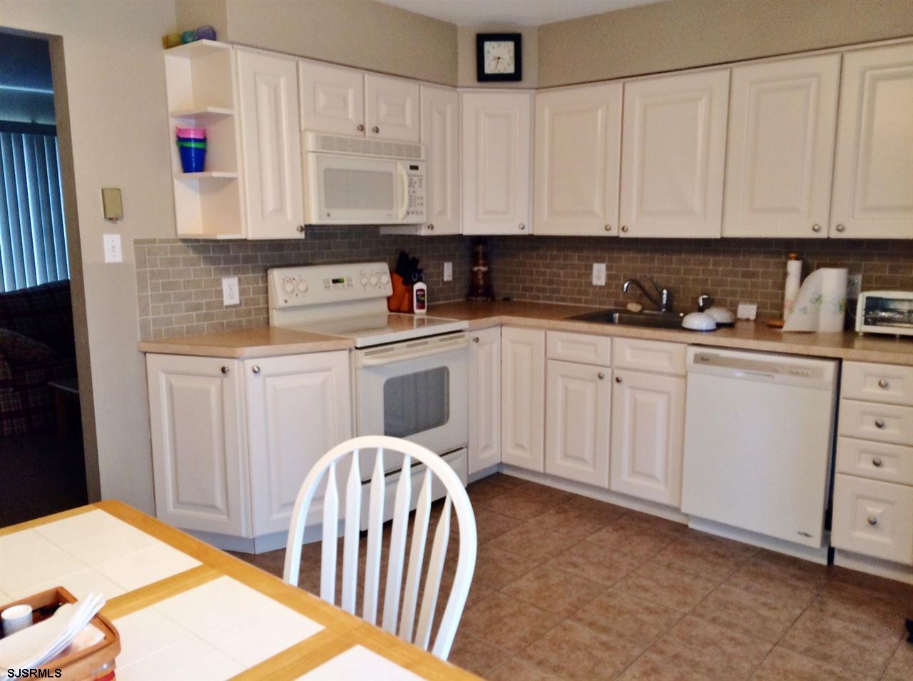 335 42nd Street South, Unit FIRST Brigantine, NJ 08203 - Photo 14 of 23 a kitchen with white cabinets sink and white appliances