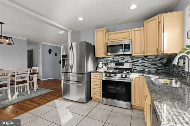a kitchen with stainless steel appliances granite countertop a stove a sink and a refrigerator