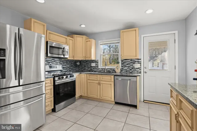 a kitchen with stainless steel appliances granite countertop a refrigerator sink and stove