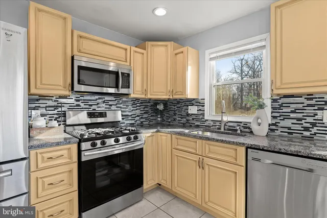 a kitchen with granite countertop a stove sink microwave and cabinets