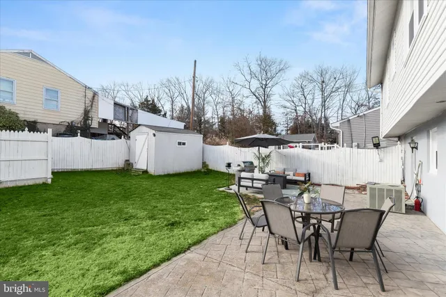 a view of a patio with a table and chairs under an umbrella