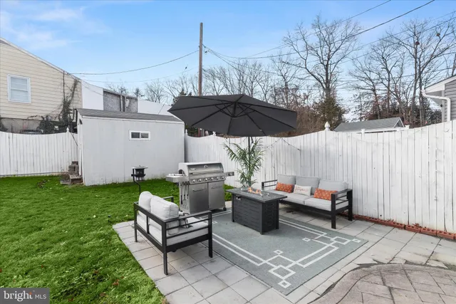 a view of a patio with couches table and chairs with wooden fence