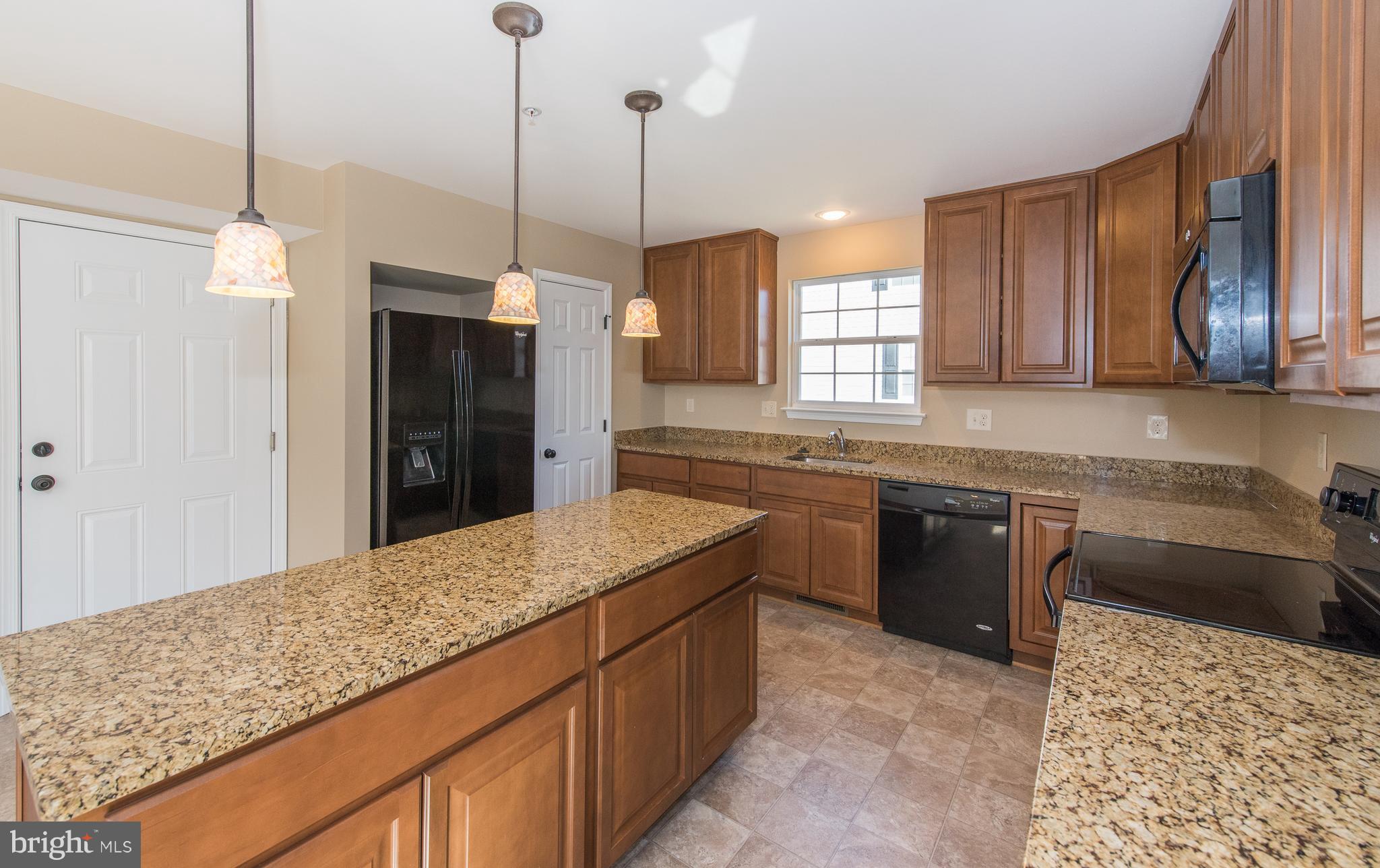 1005 Wampler Road Baltimore, MD 21220 - Photo 11 of 30 a kitchen with stainless steel appliances kitchen island granite countertop a sink stove and refrigerator