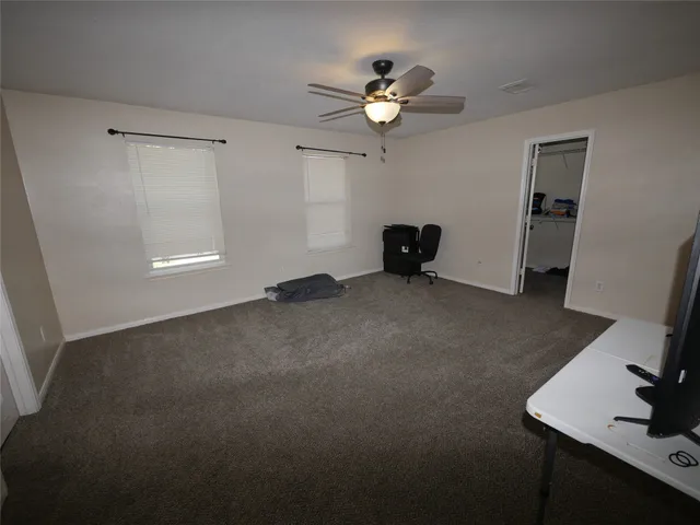 a view of an empty room with a chandelier fan