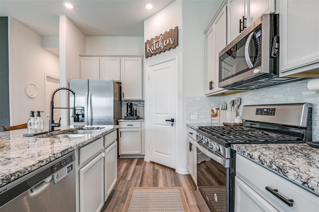 2419 Lalun Lane Forney, TX 75126 - Photo 11 of 25 a kitchen with stainless steel appliances granite countertop a sink stove cabinets and refrigerator
