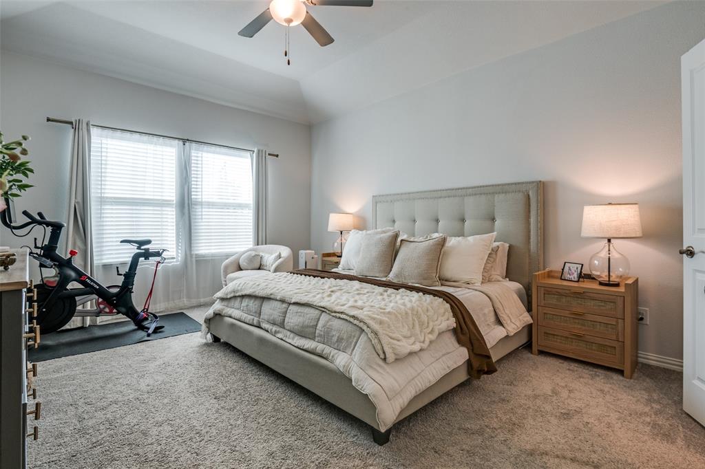 2419 Lalun Lane Forney, TX 75126 - Photo 14 of 25 a spacious bedroom with a bed a chandelier and a window