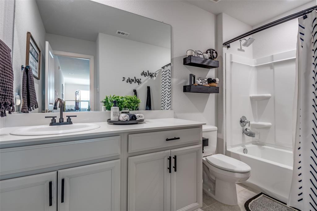 2419 Lalun Lane Forney, TX 75126 - Photo 20 of 25 a bathroom with a sink a toilet and a mirror