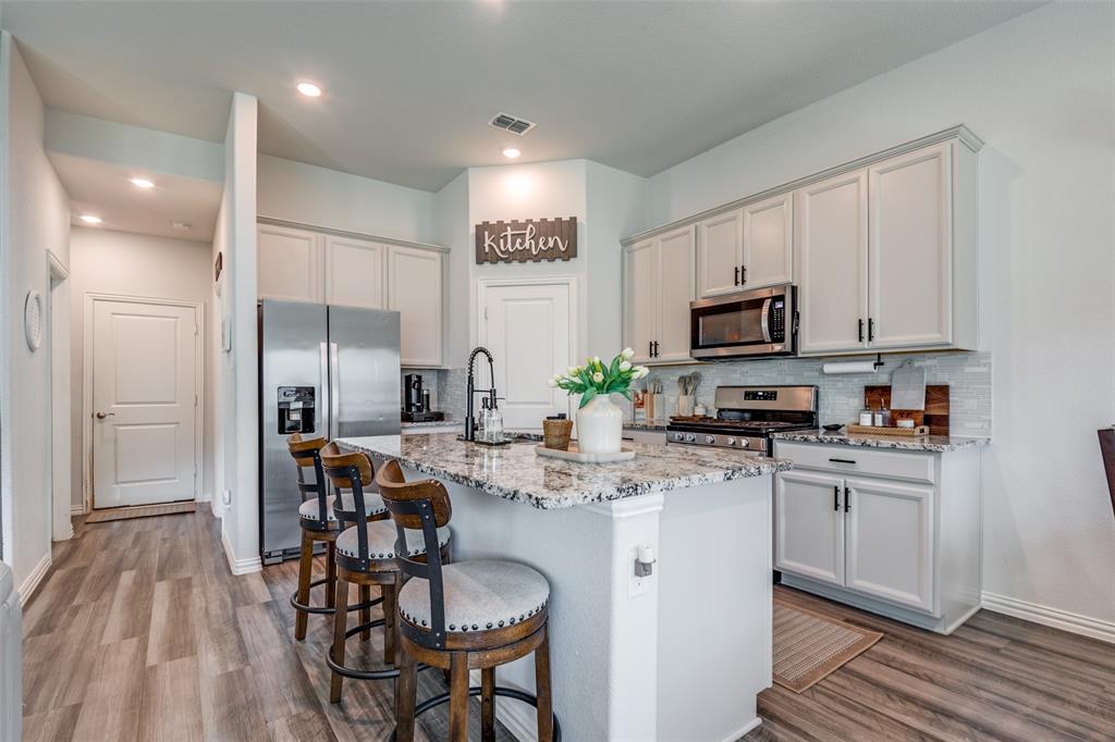 2419 Lalun Lane Forney, TX 75126 - Photo 10 of 25 a kitchen with kitchen island granite countertop a sink cabinets and stainless steel appliances