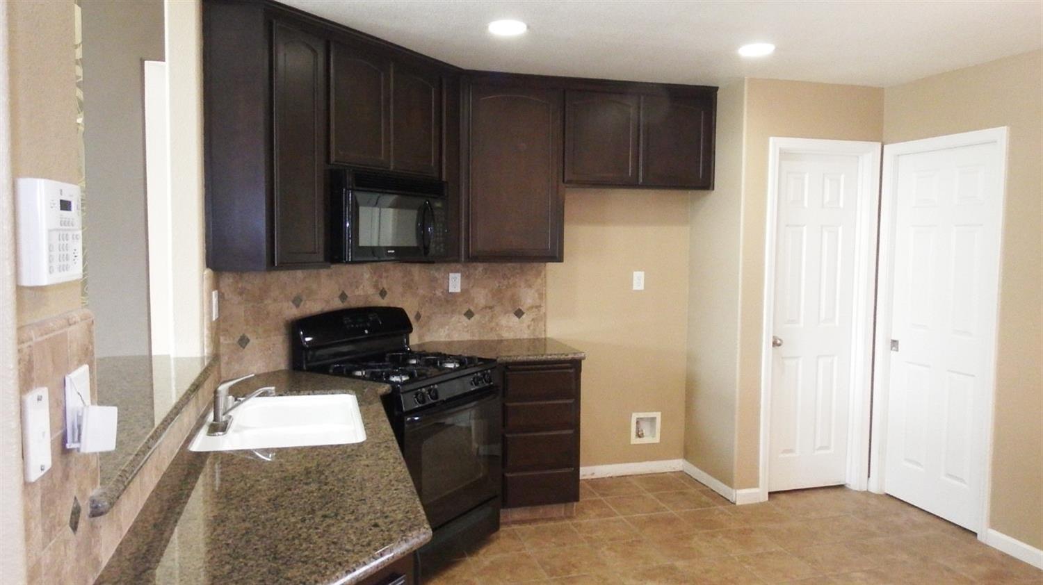 941 Marc Avenue Fowler, CA 93625 - Photo 2 of 11 a kitchen with a refrigerator stove and cabinets