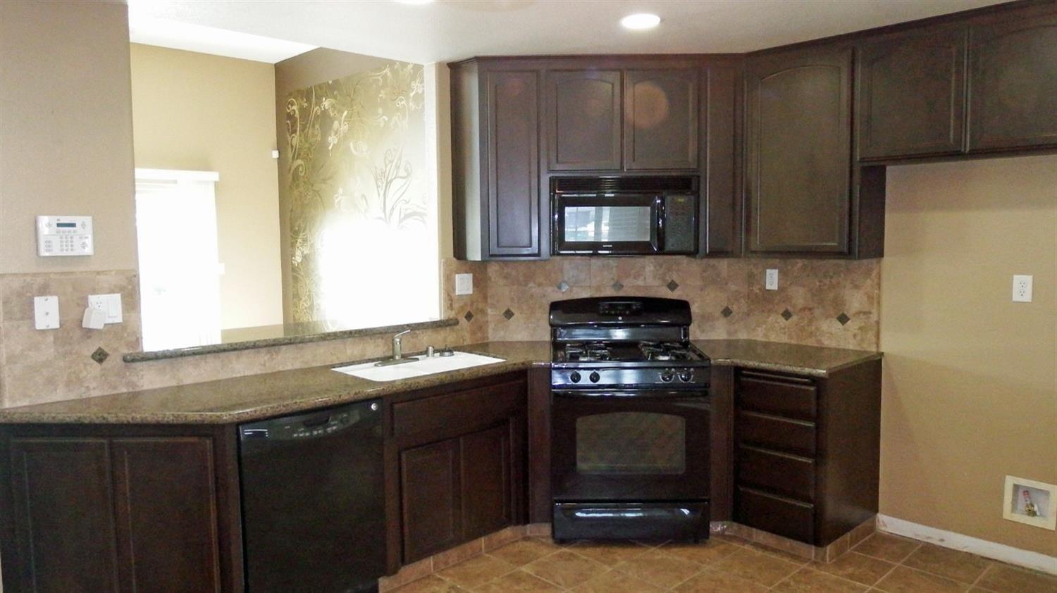 941 Marc Avenue Fowler, CA 93625 - Photo 5 of 11 a kitchen with a sink stove and microwave