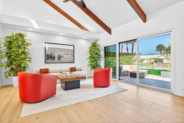 a living room with furniture a window and a potted plant